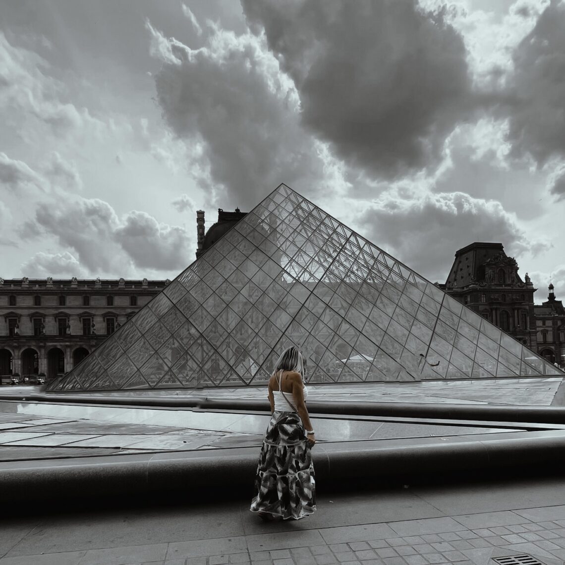 Woman walking in front of Pyramid in Louvre